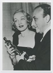 Marlene Dietrich überreicht dem Italienischen Konsul Dr. Mario Ungaro den Oscar für 'Die Mauern von Malapaga' (mit Jean Gabin) als bestem fremdsprachigen Film (Los Angeles, März 1951) (Archivtitel)