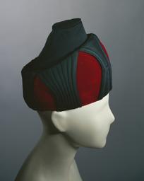 Vorschaubild zu  'Turbanähnliche Kopfbedeckung aus rotem Samt und schwarzem Stoff mit abgesteppten Formen'