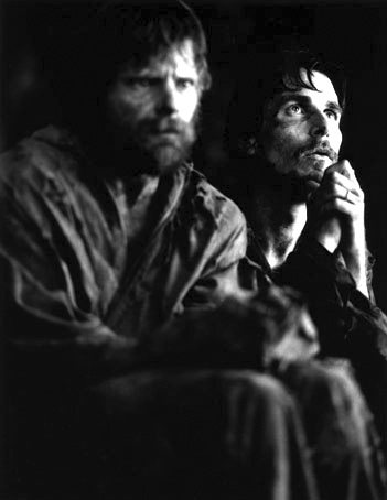 Schwarz-weiß-Foto: Zwei Männer sitzen nebeneinander und gucken nachdenklich ins Leere.
