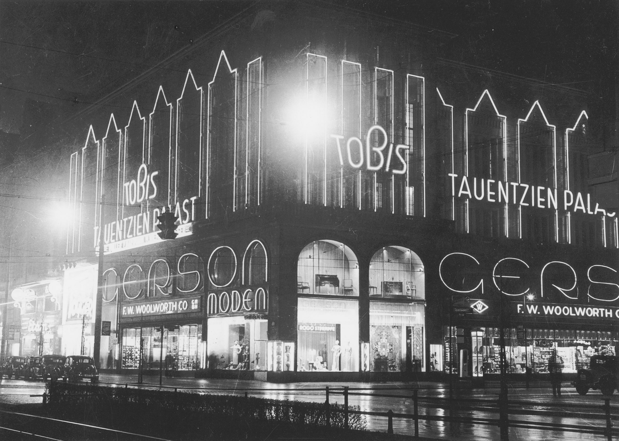 Schwarz-Weiß-Foto: nächtliches Kinogebäude mit Leuchtreklame