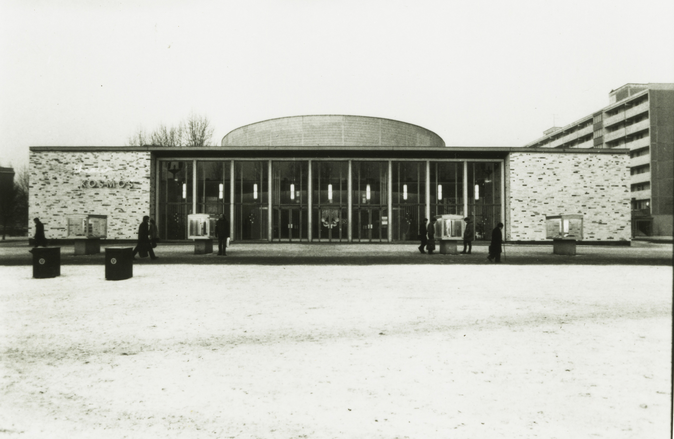 Black and white photo: cinema façade with passersby in winter