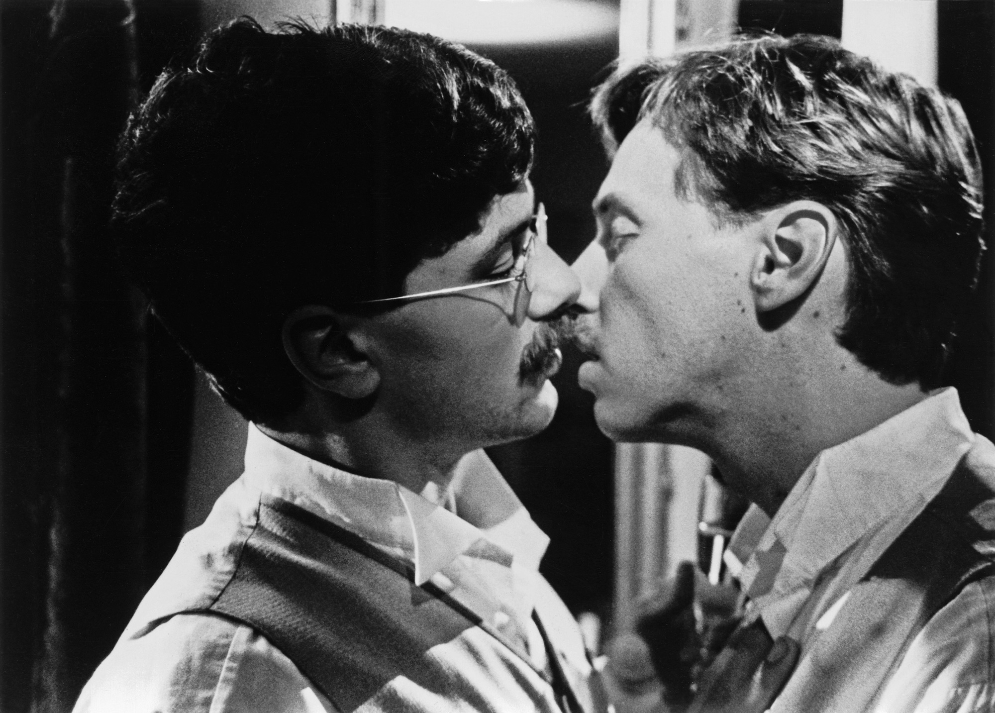 Zwei Männer im Profil küssen sich.