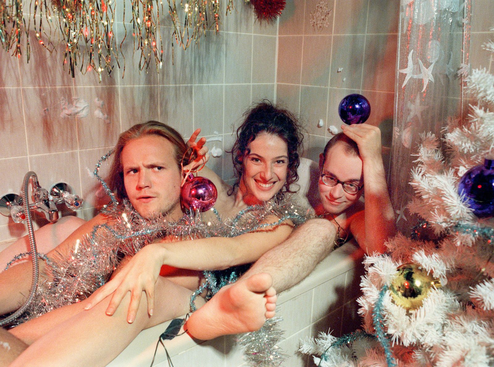 Klaus Beimer, Suzanne Richter und Philipp Sperling nackt in einer Badewanne, die weihnachtlich dekoriert ist.