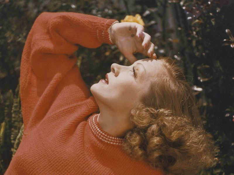 Color portrait of Marlene Dietrich in a red sweater