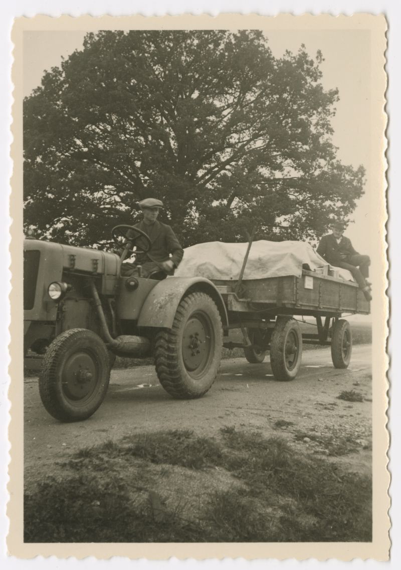 Ein Mann fährt einen landwirtschaftlichen Hänger mit Plane, darunter Kisten des Filmarchivs