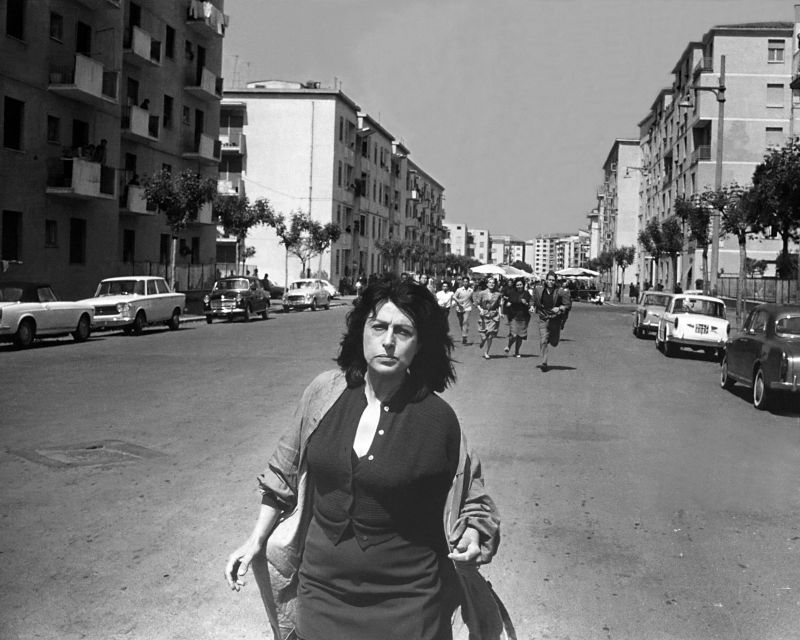 Schwarz-weiß-Szenenfoto einer Frau, die durch eine Straße rennt