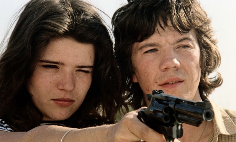 Eine junge Frau zielt mit einem Revolver. Neben ihr ein junger Mann.
