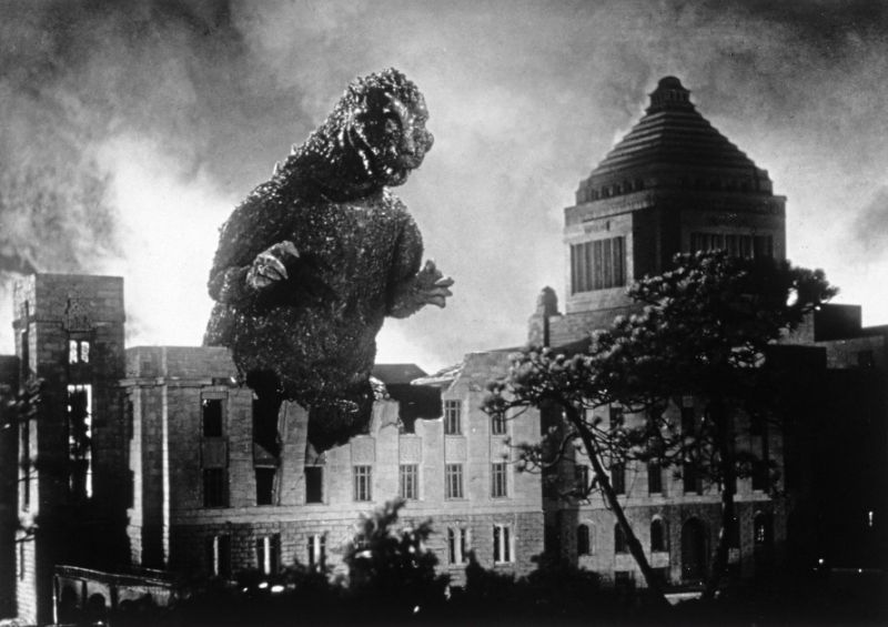 Schwarz-weiß Szenenfoto: Godzilla zwischen halb zerstörten Gebäuden