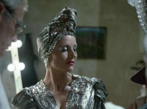 Still of a woman wearing a silver dress and a matching turban.