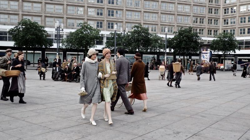 Szenenfoto aus Babylon Berlin: Zwei Frauen laufen eingehakt über den Alexanderplatz.