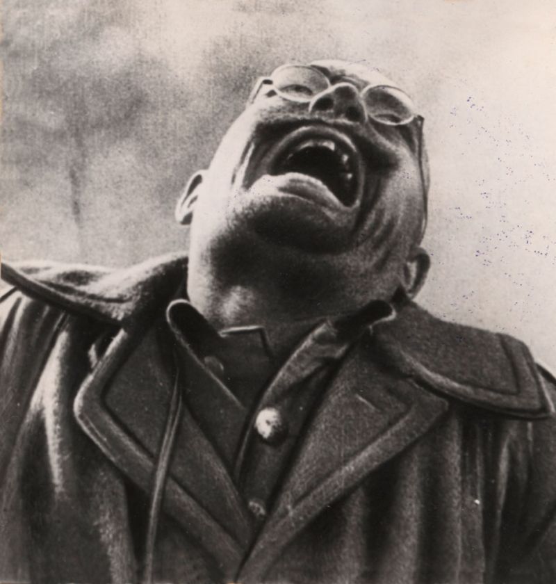 Black-and-white filmstill of a man screaming