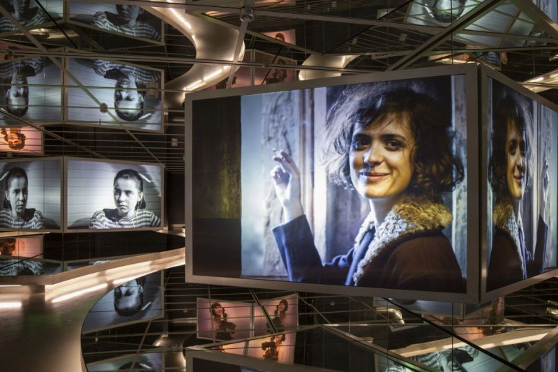 Blick in die ständige Ausstellung: Spiegelsaal Film mit Projektionen aus verschiedenen Filmen, die sich in den Spiegeln wiederholen. Auf den Bildschirmen sind verschiedene Schauspielerinnen zu sehen.