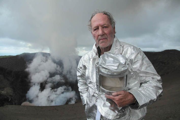 Der Regisseur steht in Schutzkleidung am Rande eines Vulkans.