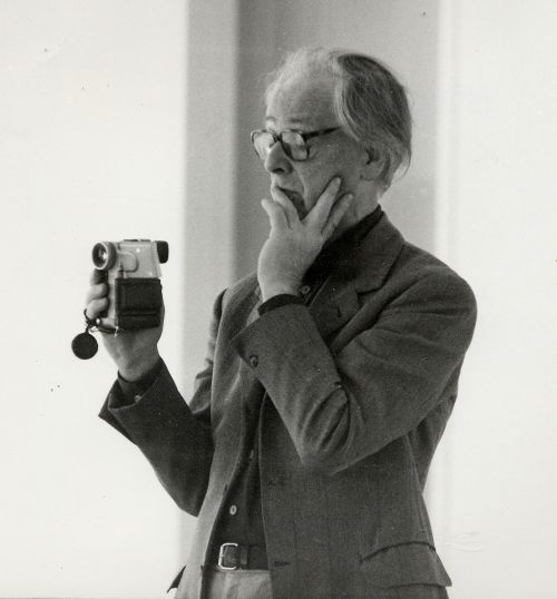 Black and white portrait of Hans Jürgen Syberberg taking a photo