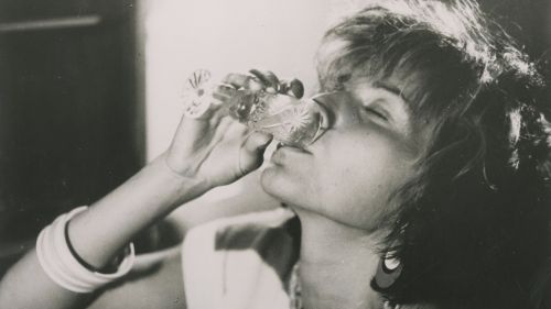 Eine junge Frau trinkt aus einem Glas