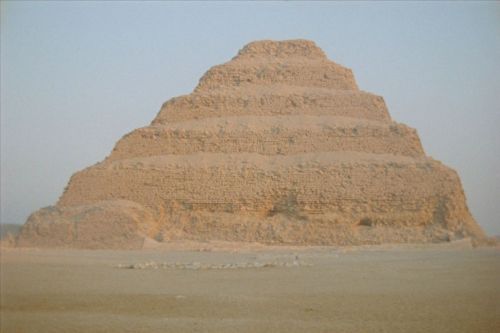 A sand-colored pyramid in front of blue skies.