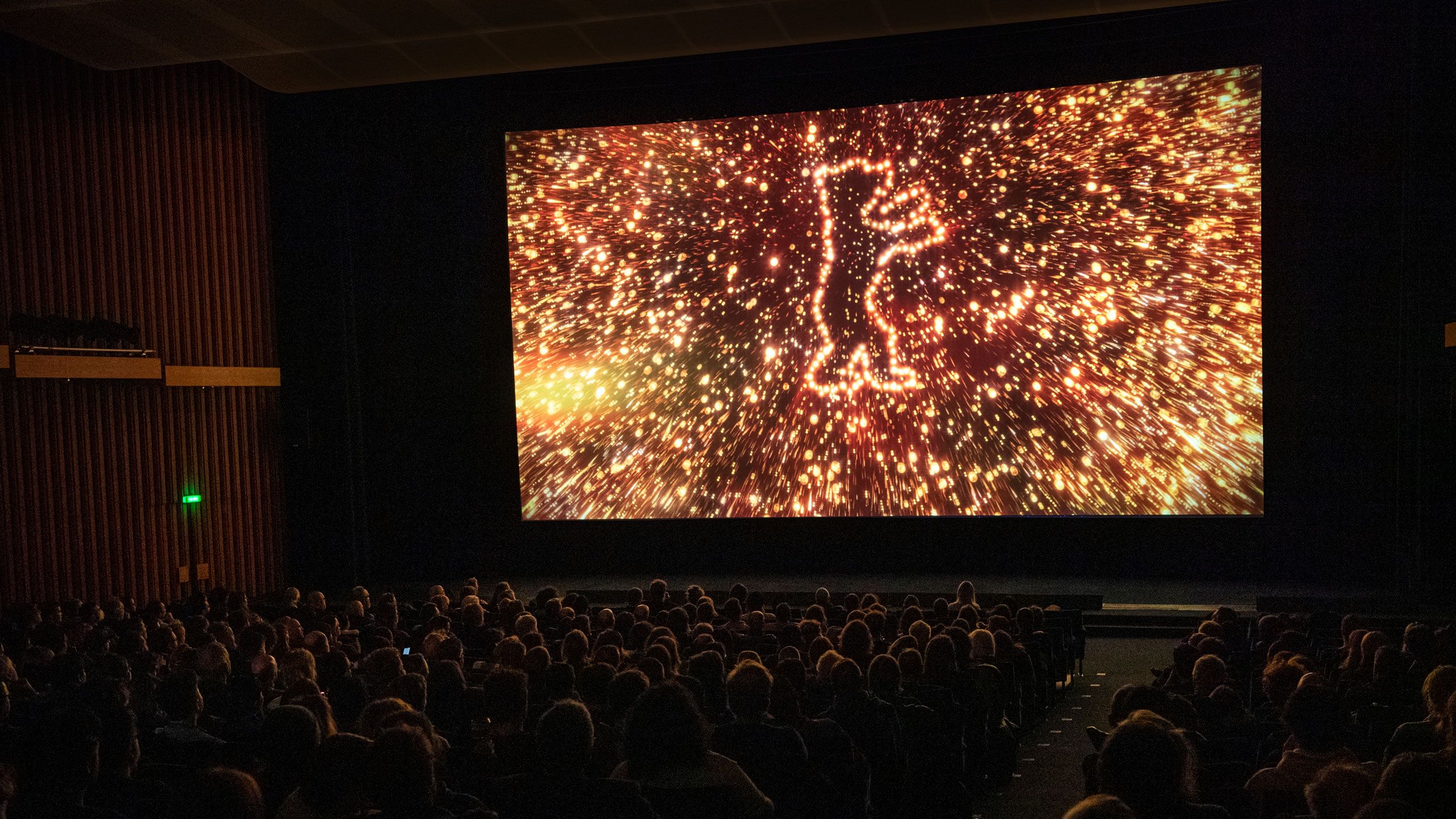 Verdunkelter Kinosaal, auf der Leinwand der funkelnde Berlinale-Bär aus dem Berlinale-Vorspann