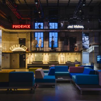 Museumsinstallation mit Filmprojektionen und Sitzlandschaft in historischer Industriehalle