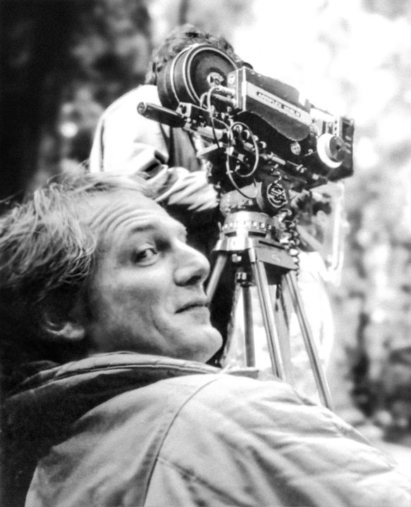 Ein Mann vor einer Kamera auf einem Stativ im Freien.