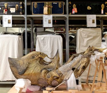 Old museum exhibits are lying in front of a shelf.