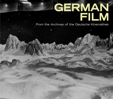 Cover: Black and white photo of a film set with a lunar landscape, cameraman and two other people in the foreground. The title is set in yellow capital letters at the top