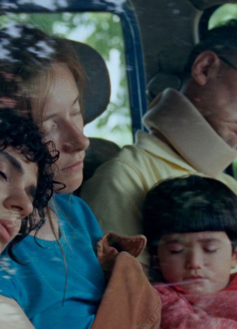 Drei Erwachsene und ein Kind sitzen schlafend in einem Auto.