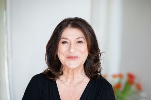 Porträt der Schauspielerin Eva Mattes, die freundlich in die Kamera lächelt.