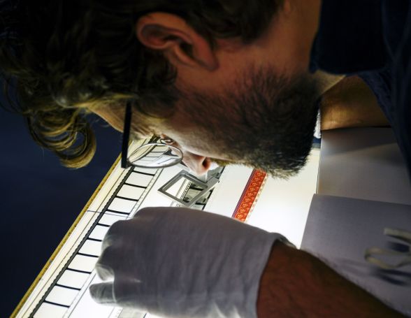 Ein Filmarchivar vergleicht Filmmaterialien des selben Films an einem Synchrontisch.