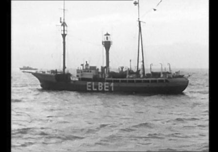 Man sieht eine schlechte Fotografie von einem Schiff auf dem Meer. Der Name ELBE1 steht auf dem Schiff. 