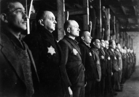 Schwarz wei&szlig; Foto, auf dem viele M&auml;nner aufgereiht stehen und nach vorne schauen. Sie tragen einen Stern auf der Brust.