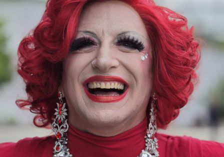 Portrait einer Drag-Queen mit rotem Haar und rotem Kleid.