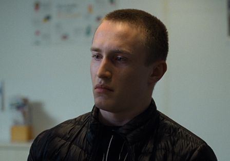 Ein junger Mann blickt nachdenklich und skeptisch nach vorn.