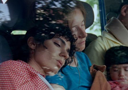 Drei Erwachsene und ein Kind sitzen schlafend in einem Auto.