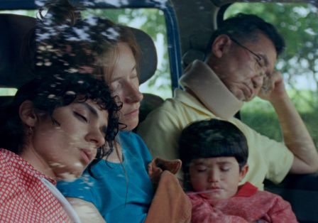 Drei Erwachsene und ein Kind sitzen schlafend in einem Auto.