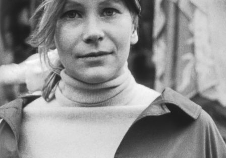 Eine junge Frau mit hellem Haar und hellen Augen blickt leicht lächelnd in die Kamera.