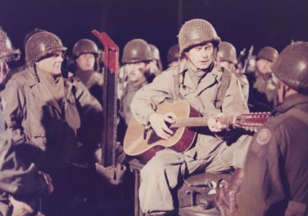 Soldaten spielen Gitarre und singen zusammen.