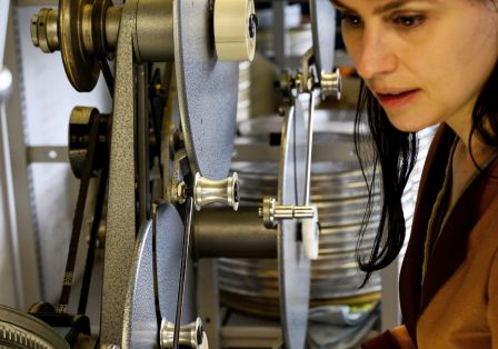 Eine junge Filmrestauratorin bereitet analoge Filmmaterialien am Abziehtisch zum Abgleich vor.