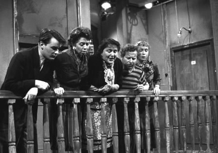 F&uuml;nf Personen lehnen sich &uuml;ber ein Gel&auml;nder und schauen nach unten.