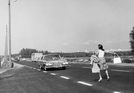 Schwarz-wei&szlig;-Foto einer Frau, die sich auf der Stra&szlig;e vor ein Auto stellt. 