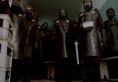 Eine Gruppe von mehreren Personen in Schutzanz&uuml;gen und Gasmasken