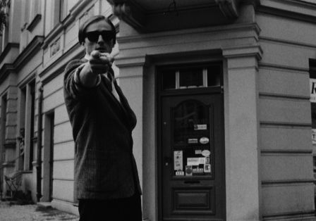 Ein junger Mann mit Sonnenbrille zeigt mit dem Finger direkt Richtung Betrachter.