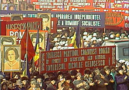 Eine gro&szlig;e Menschenmenge bei einer Demonstration mit roten Plakaten und Transparenten.
