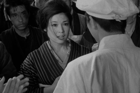 Eine Frau blickt eindringlich auf einen Mann, den wir von hinten sehen. A woman looks intensely at a man, who is seen from behind.