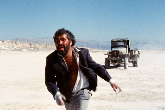 Ein Mann rennt in einer w&uuml;sten&auml;hnlichen Landschaft vor einem Wagen davon.