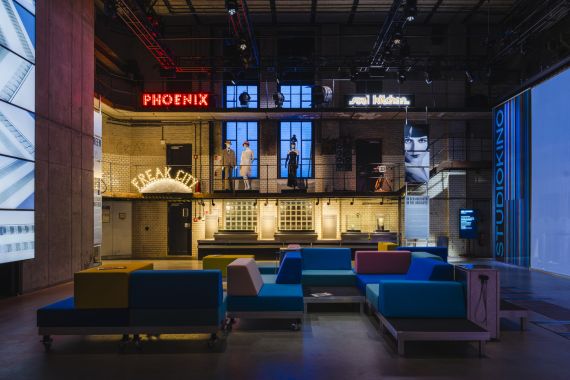 Museumsinstallation mit Filmprojektionen und Sitzlandschaft in historischer Industriehalle