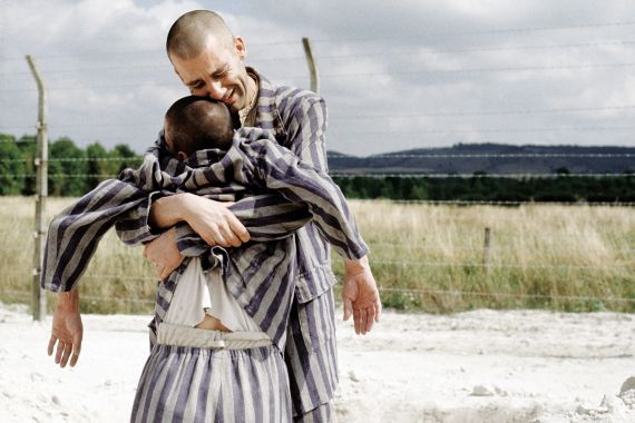 Zwei H&auml;ftlinge im Konzentrationslager: Ein Mann umarmt heftig einen anderen (scheinbar leblosen) Mann