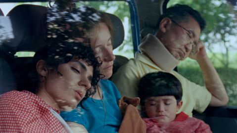 Drei Erwachsene und ein Kind sitzen schlafend in einem Auto.