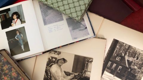 Mehrere B&uuml;cher und Fotoalben auf einem Tisch.