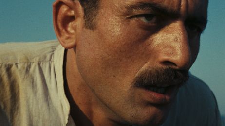 Ein Mann schaut vor einem blauen Himmel streng in die Ferne.