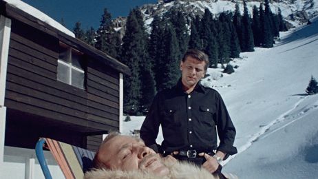 Zwei M&auml;nner in den Bergen, einer liegt auf einer Liege, der andere steht hinter ihm..